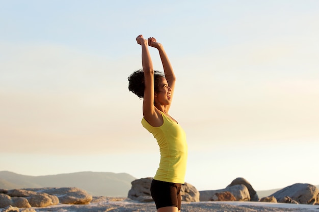 Femme jeune sport acclamant avec les bras levés à l&#39;extérieur