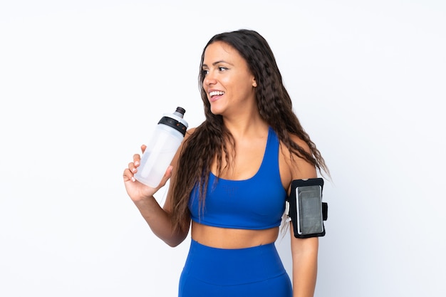 Femme jeune sport sur blanc isolé avec bouteille d'eau de sport