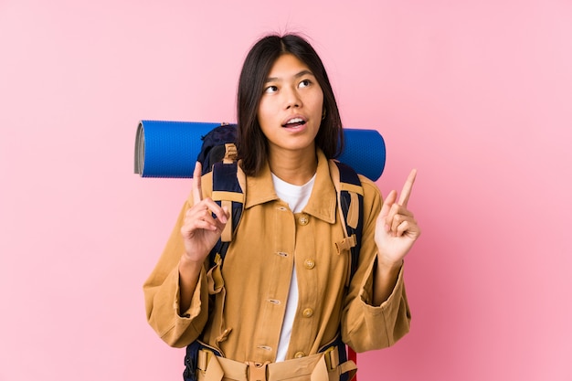 Femme jeune voyageur chinois isolé pointant à l'envers avec la bouche ouverte.