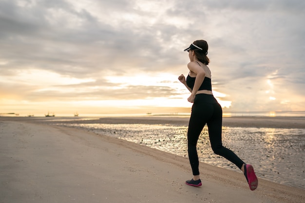 Femme jogging sur la plage le matin