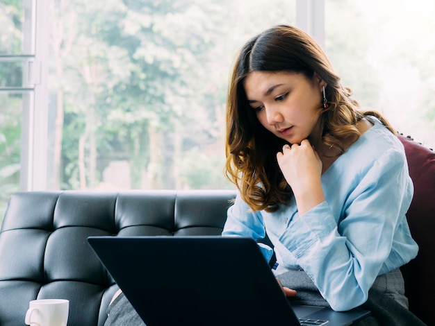 Femme jolie asiatique Internet travaille en ligne à la maison et se détendre style de vie avec son labtop