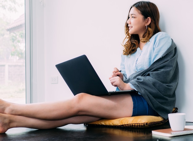 Femme jolie asiatique Internet travaille en ligne à la maison et se détendre style de vie avec son labtop