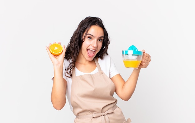 Femme jolie chef hispanique préparant un jus d'orange