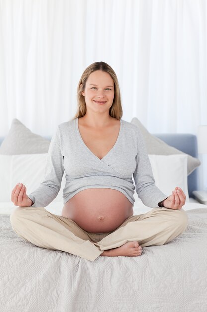 Femme jolie enceinte, faire du yoga