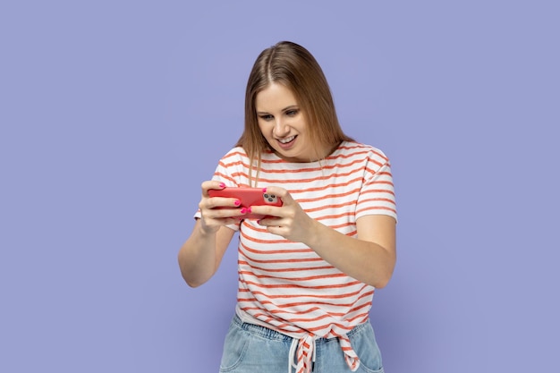 Femme jouant au jeu sur un téléphone intelligent exprimant de bonnes émotions en appréciant son jeu