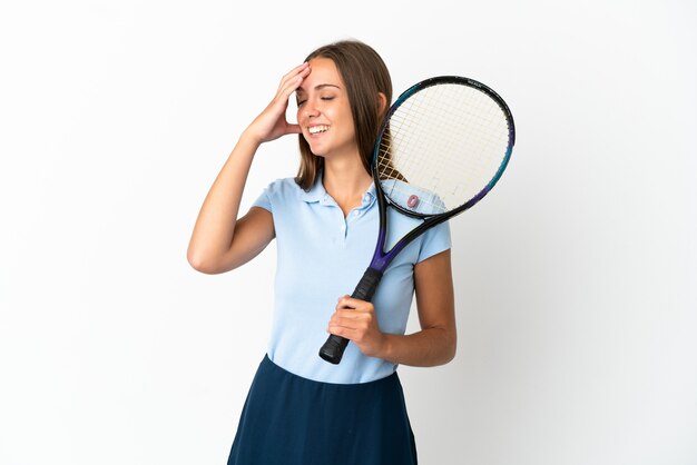 Femme jouant au tennis sur un mur blanc isolé souriant beaucoup