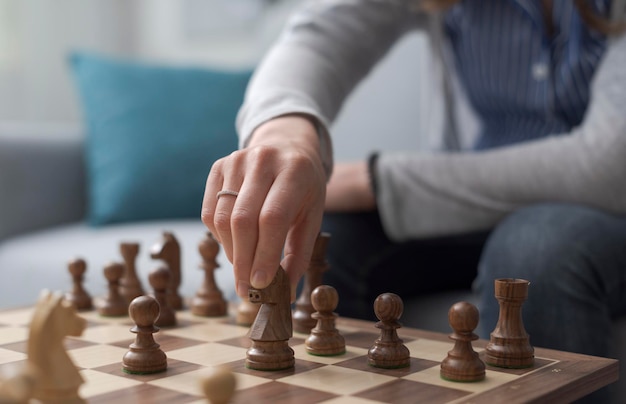 Femme jouant aux échecs main bouchent