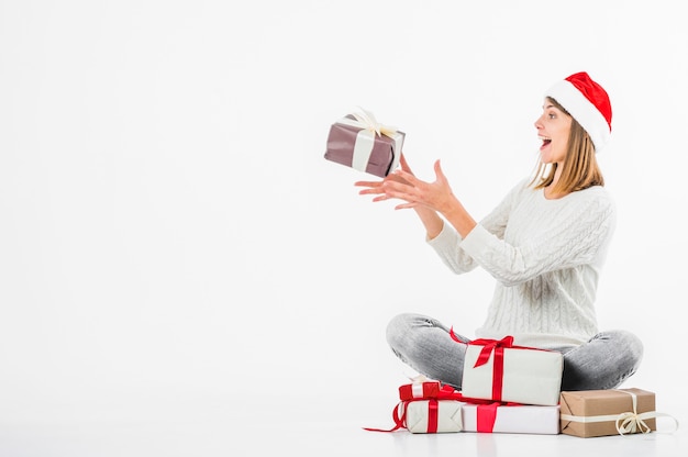 Femme jouant avec une boîte cadeau au sol