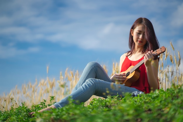 femme jouant du ukulélé dans le jardin.