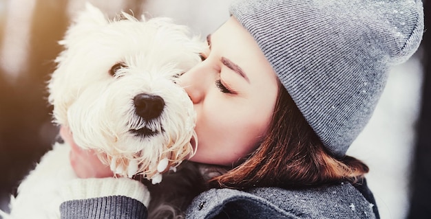 Femme joue avec un chien terrier blanc