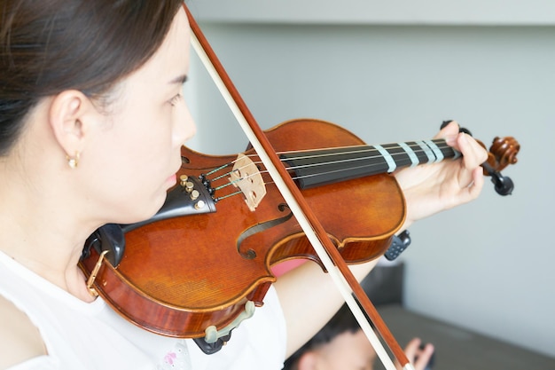 une femme joue du violon dans la musique comme un musicien ou un violoniste montre une chaîne en portrait avec soleil