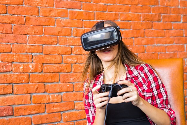 Une femme joue à un jeu vidéo avec un joystick avec un appareil VR