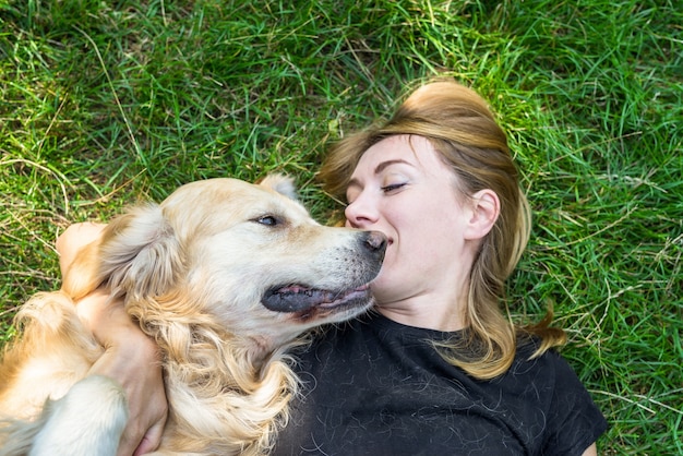 Une femme joue avec son chien retriever à l'extérieur.