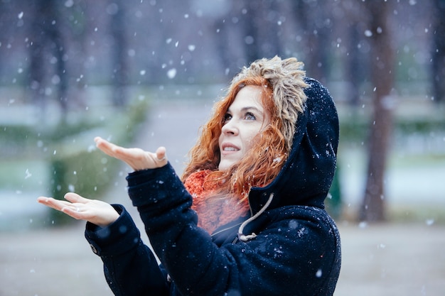 Femme, jouer, flocons neige, dehors