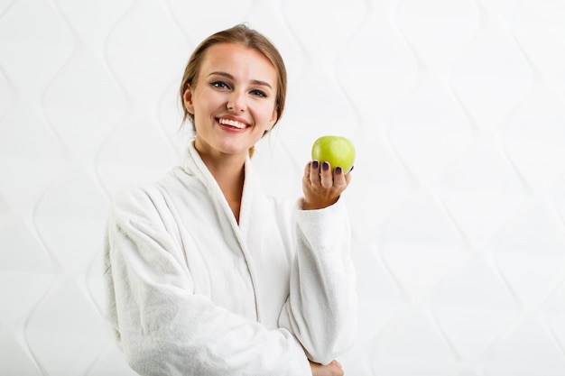 Une femme joyeuse aime la pomme