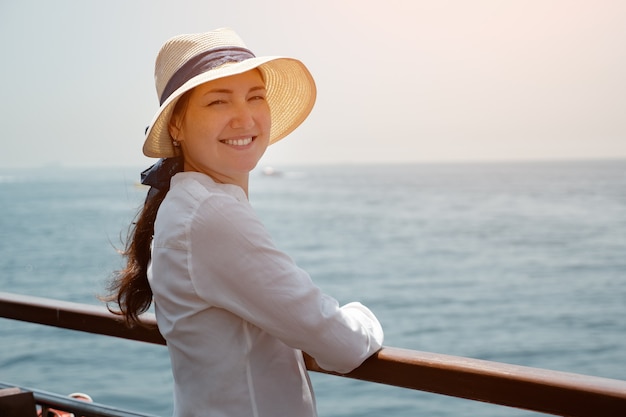 Une femme joyeuse aime le voyage et regarde la caméra