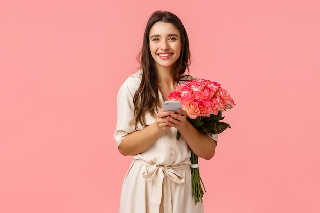 femme joyeuse avec de belles fleurs et smartphone