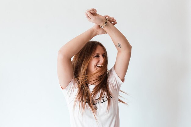 Femme joyeuse avec les bras levés debout sur un fond blanc