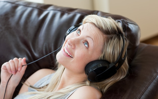 Femme joyeuse avec un casque sur un canapé