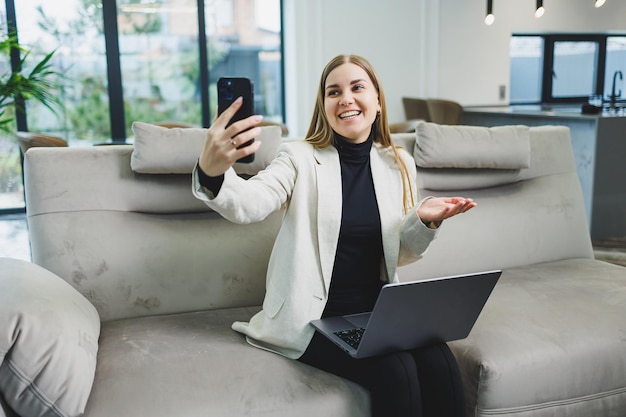 Femme joyeuse charmante personne assise derrière un netbook regardant avoir une bonne humeur travaillant à la maison à l'intérieur Travail indépendant à distance