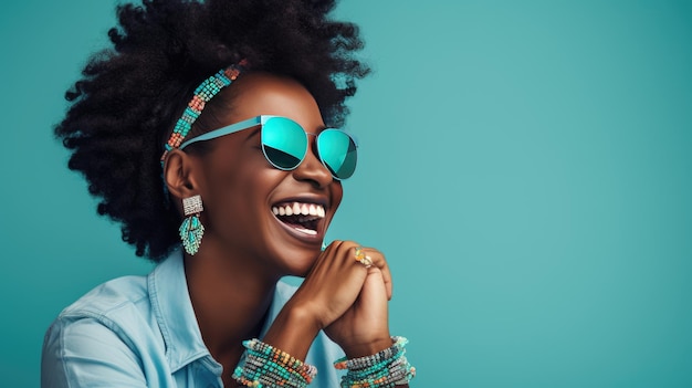 Une femme joyeuse avec une coiffure afro riant et portant des lunettes de soleil turquoise sur un fond turquoise vibrant