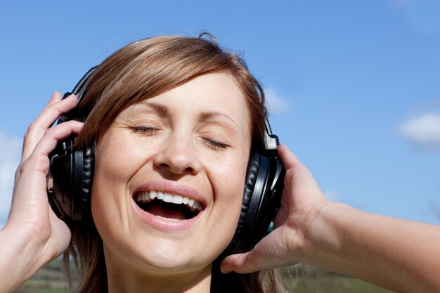 Femme joyeuse écoute de la musique en plein air