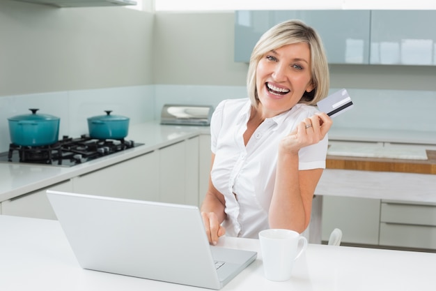 Femme joyeuse, faire des achats en ligne dans la cuisine