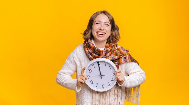 Femme joyeuse avec horloge en studio