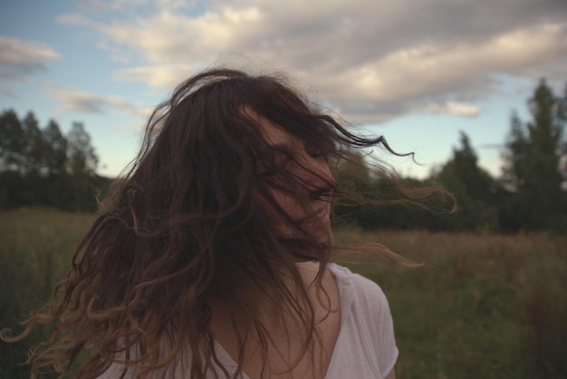 Une femme joyeuse jetant des cheveux sur le terrain