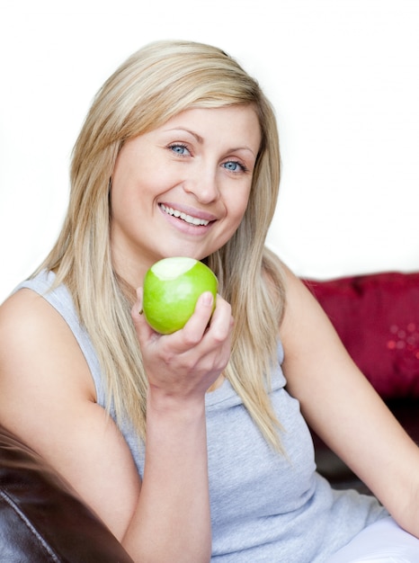 Femme joyeuse mange une pomme