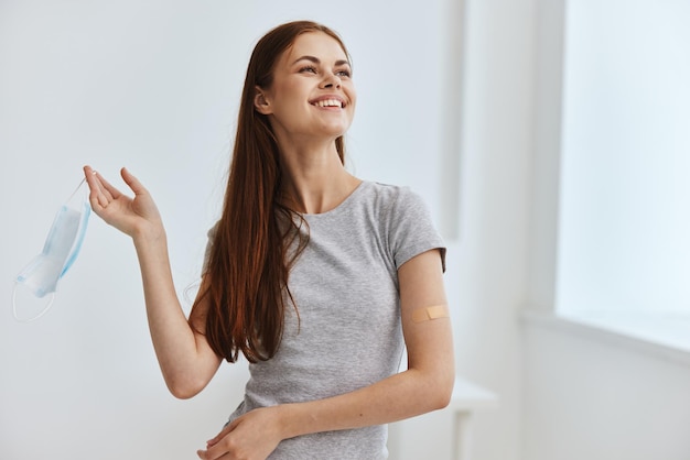 Femme joyeuse avec un masque médical dans les mains vaccination protection de l'immunité photo de haute qualité