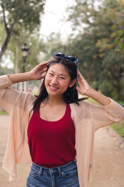 Une femme joyeuse met ses lunettes de soleil sur ses cheveux