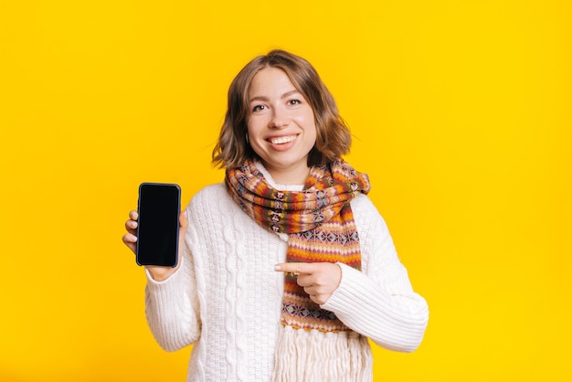 Femme joyeuse montrant un smartphone moderne