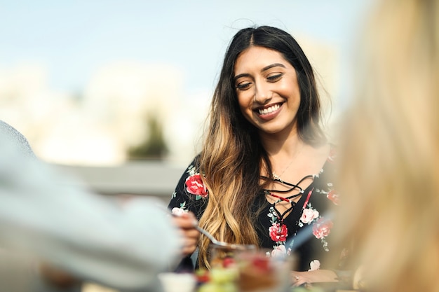 Femme joyeuse profitant d&#39;une fête sur le toit avec ses amis