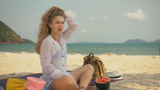 La femme joyeuse en tenant et en mangeant des tranches de pastèque sur la mer de plage de sable tropical. Portrait jolie fille passer le week-end d'été.