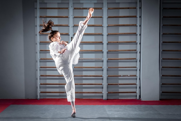 La femme de karaté avec ceinture noire Sport femme combat pose coup de poing en robe uniforme de sport Taekwondo karaté