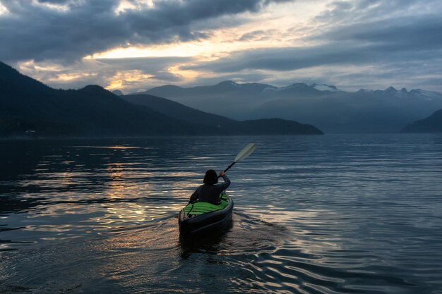 Femme kayak autour du paysage de montagne canadien