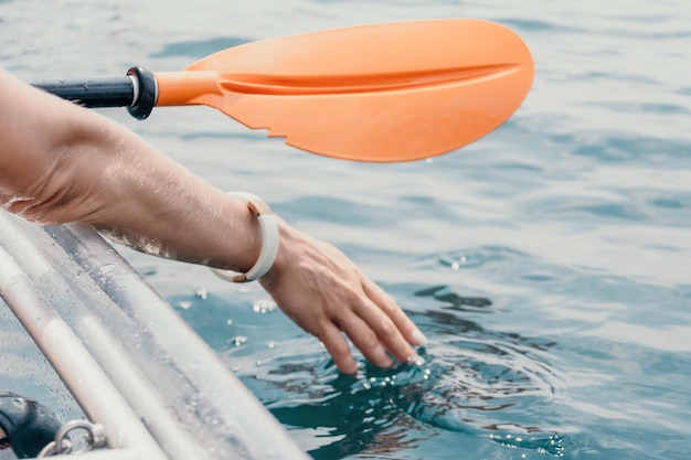 Femme en kayak vue arrière heureuse jeune femme aux cheveux longs flottant en kayak transparent sur le