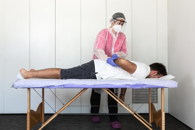 femme kinésithérapeute ostéopathe chiropraticien fait des exercices de rééducation massages un patient