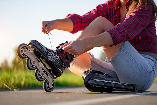 Femme lacets patinage à roulettes pour le patin à roues alignées. Adolescent en patin à roues alignées à l'extérieur.