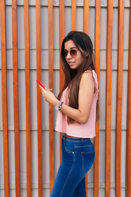 Femme latina textos sur téléphone portable dans la rue