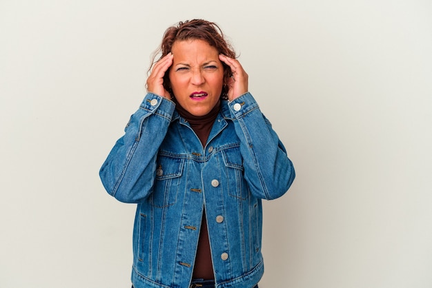 Femme latine d'âge moyen isolée sur fond blanc couvrant les oreilles avec les doigts, stressée et désespérée par une ambiance bruyante.