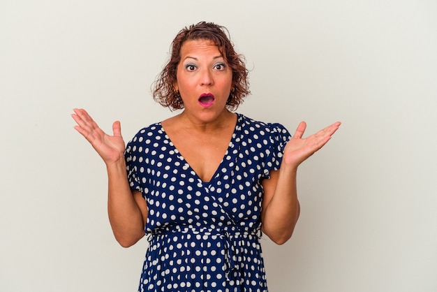 Femme latine d'âge moyen isolée sur fond blanc surprise et choquée.