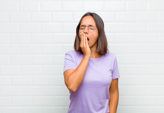 Femme latine bâillant paresseusement tôt le matin, se réveillant et à la somnolence, fatiguée et ennuyée