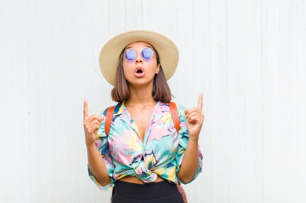 Femme latine à la choqué et pointant vers le haut