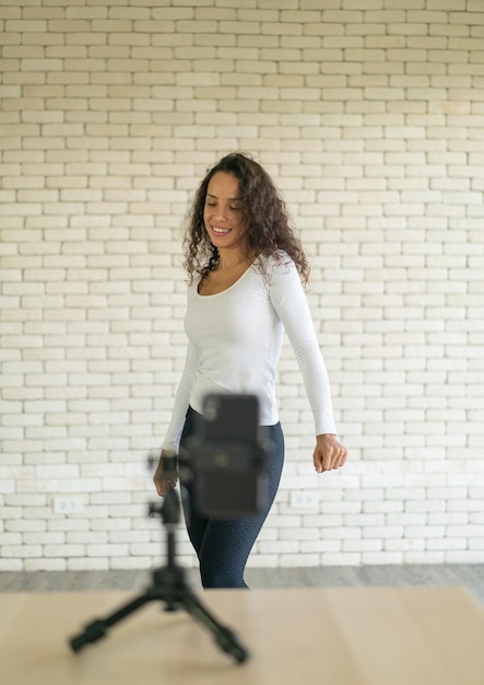 Une femme latine a créé sa vidéo de danse avec l'appareil photo d'un smartphone Pour partager une vidéo avec une application de médias sociaux