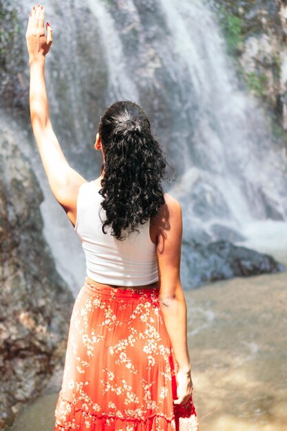 Femme latine debout près d'une cascade. Concept de vacances et de tourisme