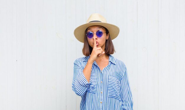 Femme latine demandant le silence et la tranquillité, faisant des gestes avec le doigt devant la bouche, disant chut ou gardant un secret