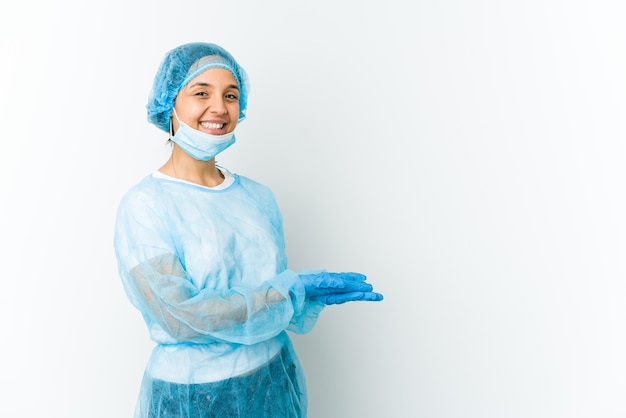 Femme latine jeune chirurgien tenant un espace de copie sur une paume.