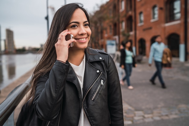 Femme latine parlant au téléphone.